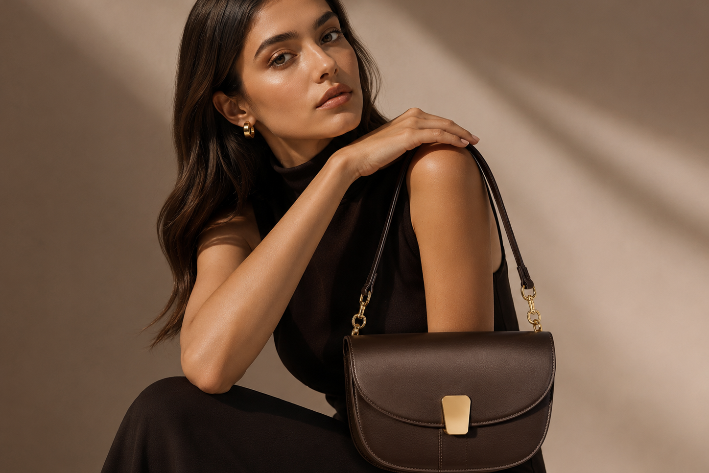 Woman holding a brown handbag against a beige background